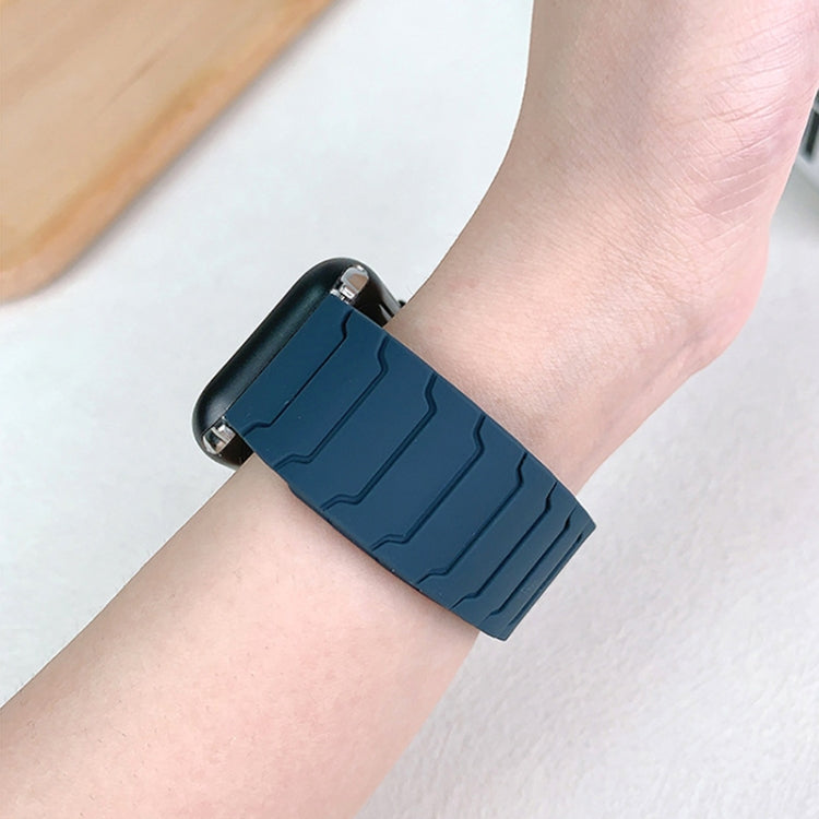Back view of a dark blue silicone watch band worn on a wrist