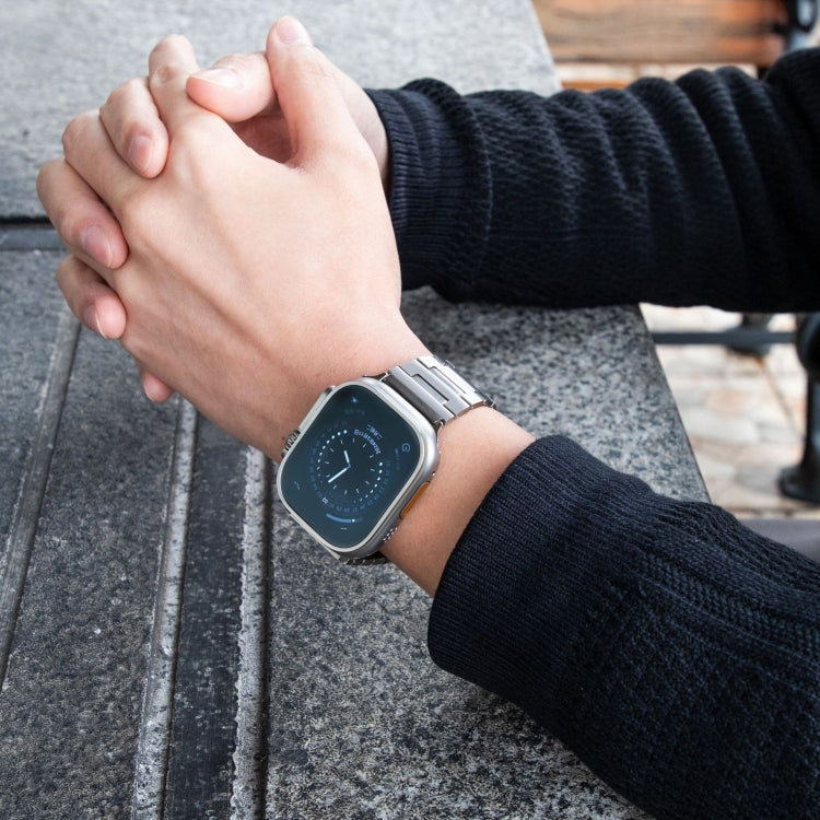 Silver titanium alloy watch band worn on the wrist with an Apple Watch.