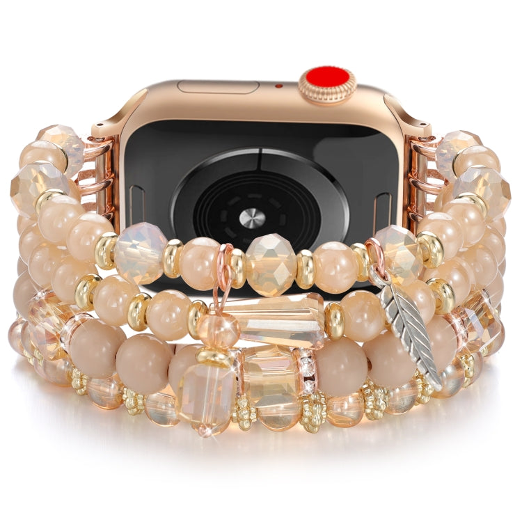 Peach beaded Apple Watch band with gold spacers and dangling crystal and leaf charms
