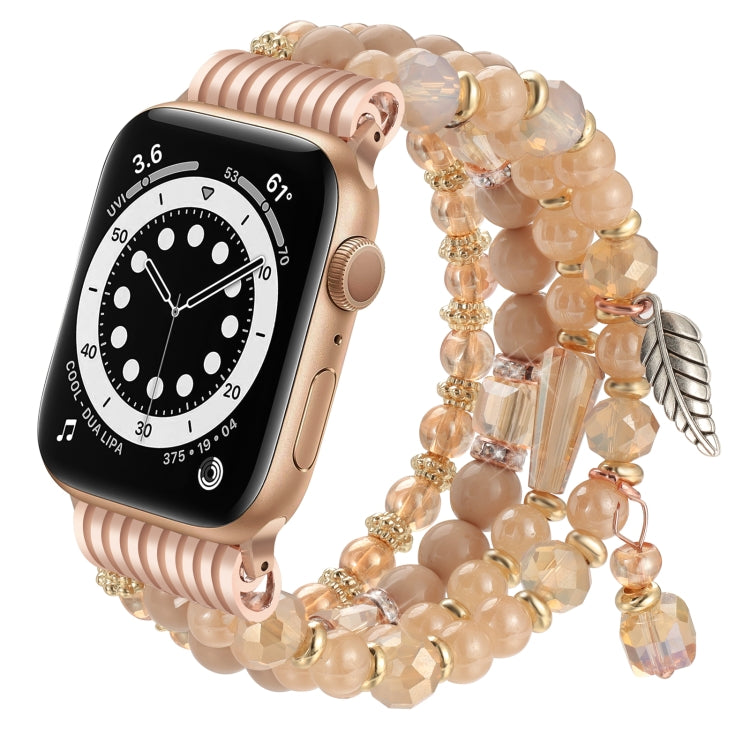 Peach beaded Apple Watch band with gold accents and dangling crystal and leaf charms