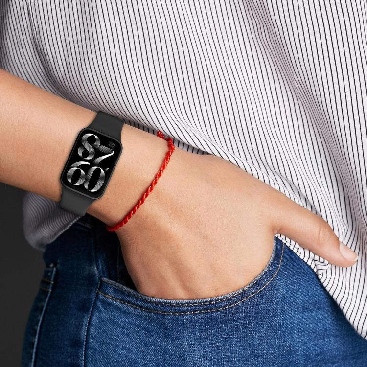 Black silicone watch band with buckle worn on a wrist