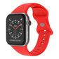 Bright red silicone Apple Watch band with butterfly buckle, shown attached to a watch