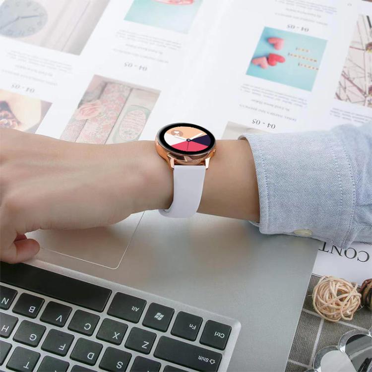White silicone watch band worn with a round smartwatch