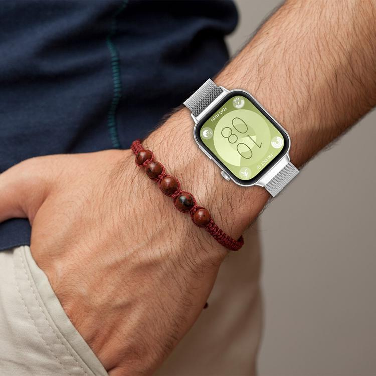 Silver Milanese metal watch band fitted to a smartwatch on a wrist
