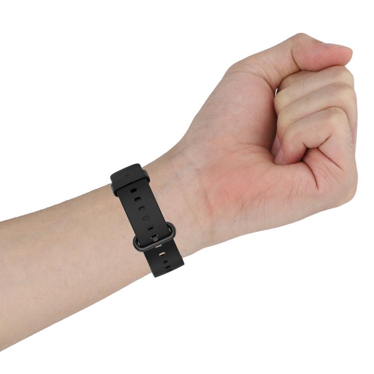 Black silicone watch band fastened around a wrist