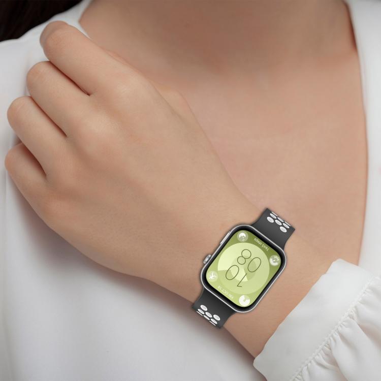 Black and white perforated silicone sports watch band worn on a wrist