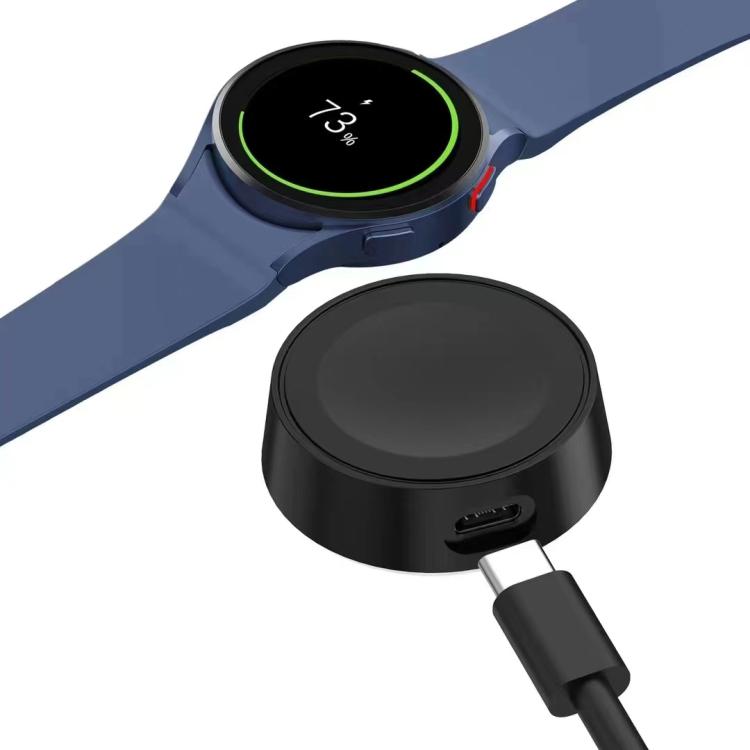 Black xDfind magnetic smartwatch charger with cable beside a charging smartwatch