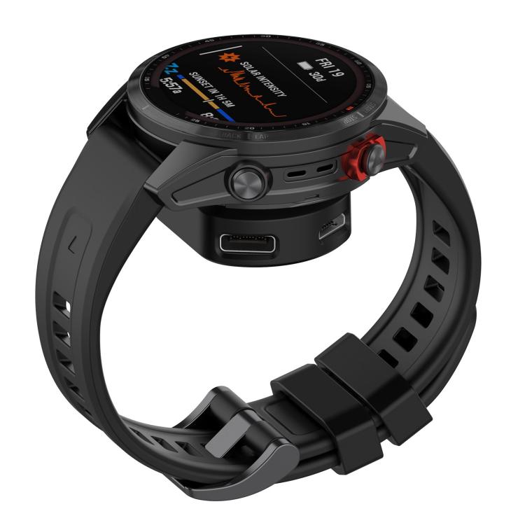 Black Garmin smartwatch connected to a compact charging adapter