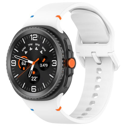 White silicone watch band fitted to a round smartwatch, with buckle and adjustment holes.