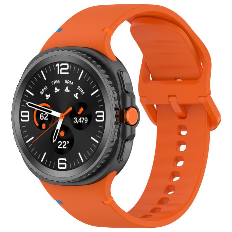 Orange silicone watch band with adjustable holes and buckle, fitted to a black smartwatch.