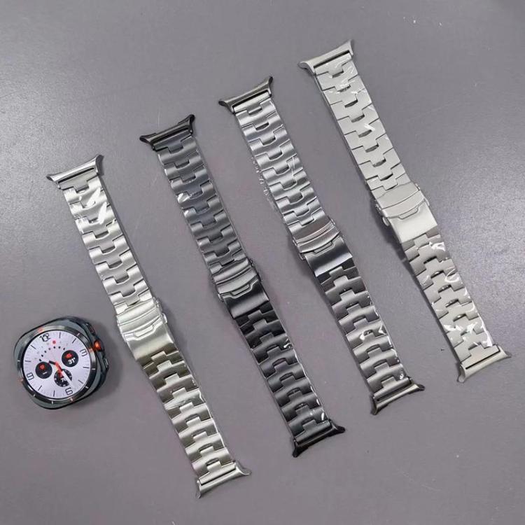Four linked titanium alloy watch bands in silver, gray, and black beside a watch