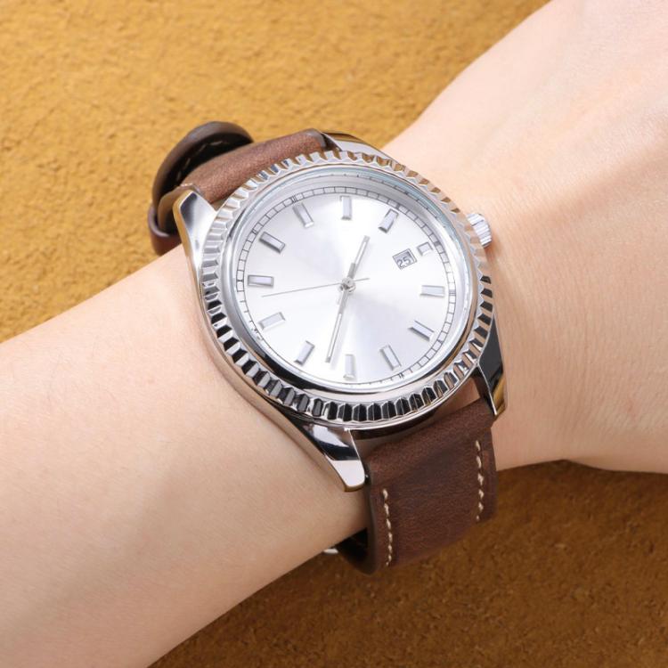 Brown leather watch band worn on wrist with a silver watch