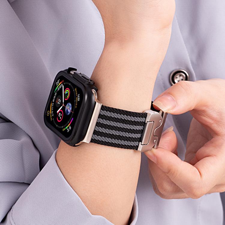 Black and gray striped nylon watch band with a silver buckle worn on a wrist