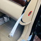 Light gray trim removal tool with loop ring prying open a car interior panel gap