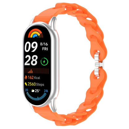 Orange hollow-link silicone watch band fitted to a smartwatch.