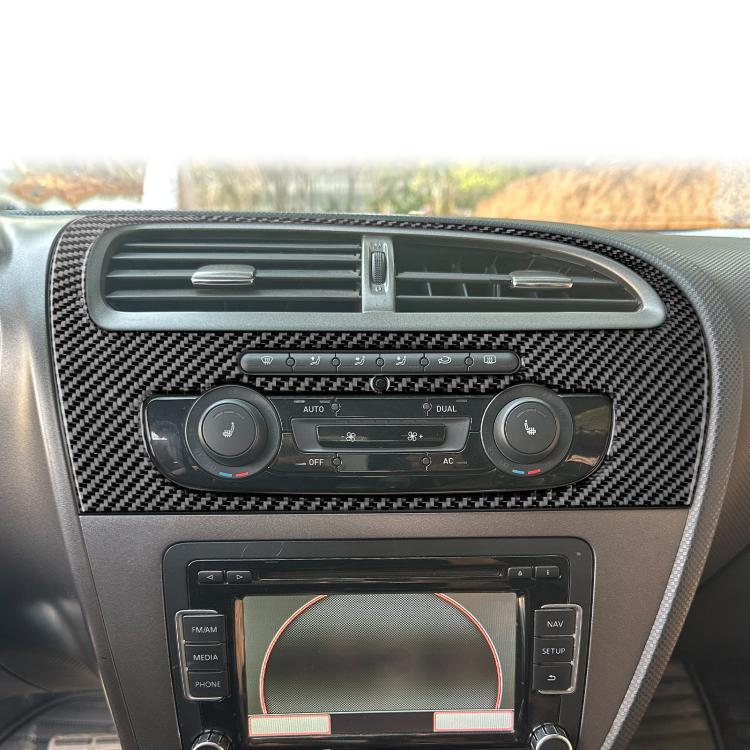 Black carbon-fiber center console trim panel around air vents and control knobs