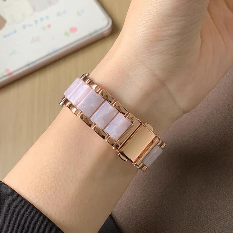 Close-up of a rose gold watch band with pale pink resin links on a wrist