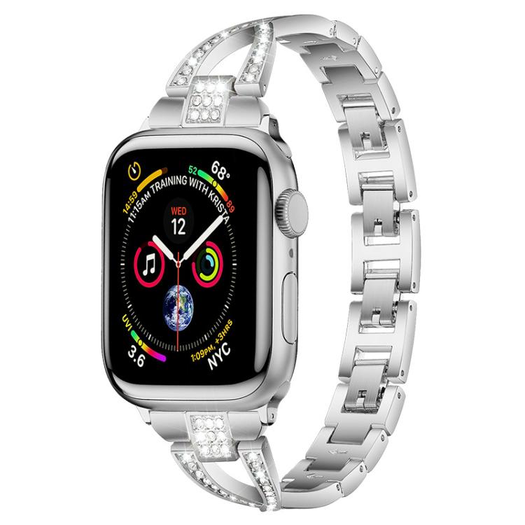 Silver X-shaped metal Apple Watch band with crystal accents, shown attached to a watch