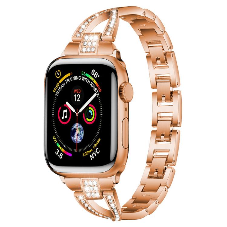 Rose gold X-shaped metal Apple Watch band with crystal accents, shown attached to a watch