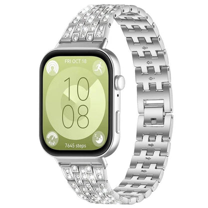 Silver metal smartwatch band with five rows of clear stones, shown on a smartwatch.