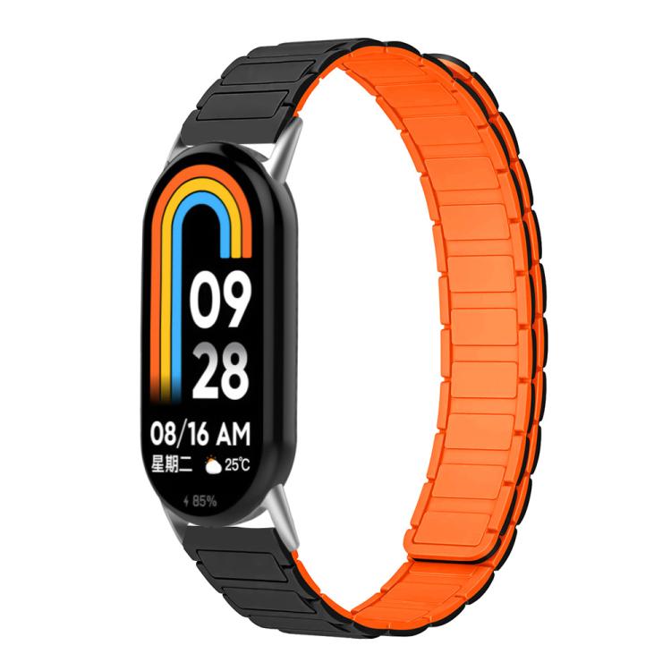 Two-tone silicone watch band in black and bright orange, shown on a smart band.