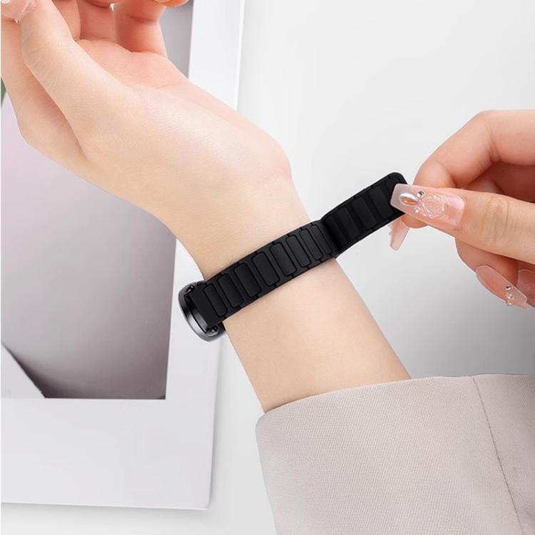 Black magnetic silicone watch band with segmented links, shown wrapped around a wrist.