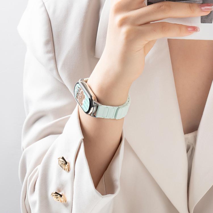 Light mint silicone watch band with segmented links, worn with a smartwatch.