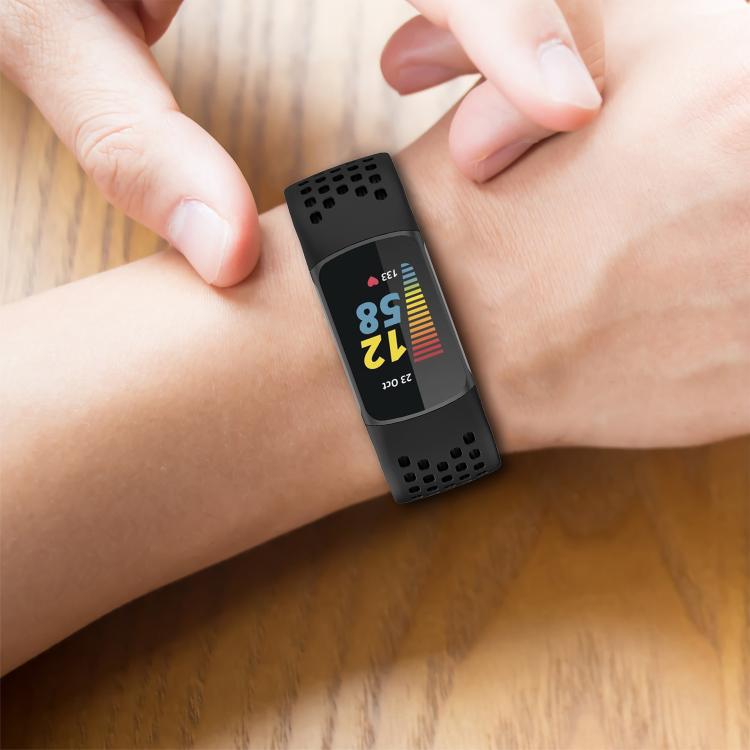 Black perforated watch band worn on a wrist with a fitness tracker