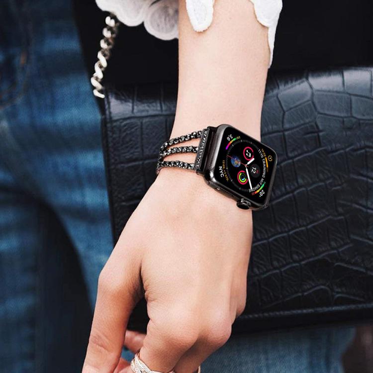 Black three-row rhinestone metal Apple Watch band worn on a wrist