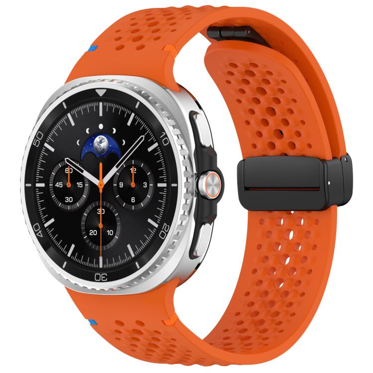 Orange perforated silicone watch band with black magnetic buckle, shown on a watch