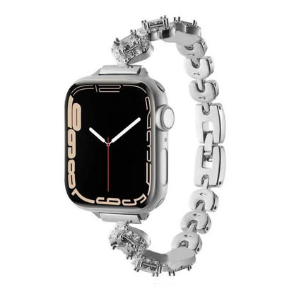 Silver metal Apple Watch band with crystal four-leaf clover links, shown attached to a watch