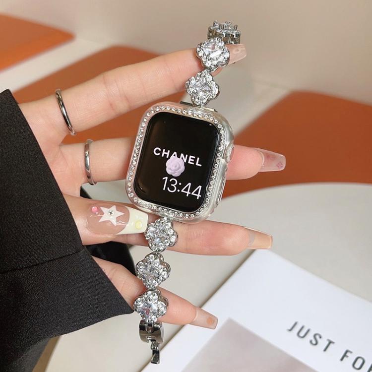Silver metal Apple Watch band with crystal clover links, worn with a watch