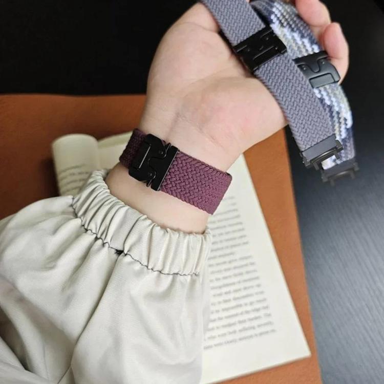 Plum braided watch band with black snap buckle worn on a wrist; gray band held nearby