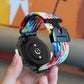 Multicolor braided watch band attached to a black smartwatch, showing the snap buckle