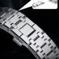 Close-up of a silver titanium alloy watch band clasp and interlocking links.