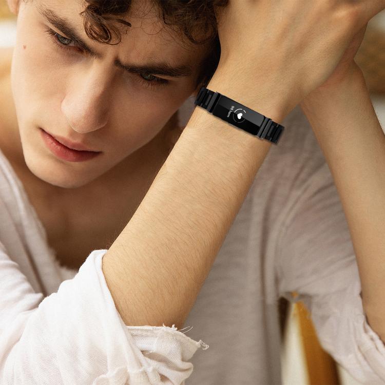 Black stainless steel Fitbit band with slim links, worn on a wrist