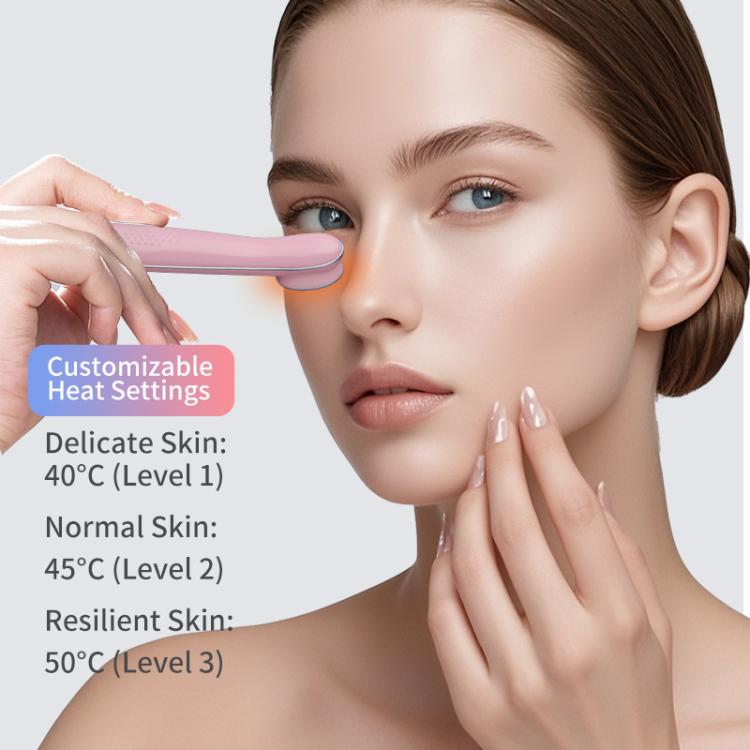 Pink hot compress eye massager gently pressed near the face with oval head.