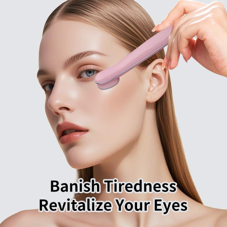 Pink hot compress eye massager positioned on the eye area for warming massage.