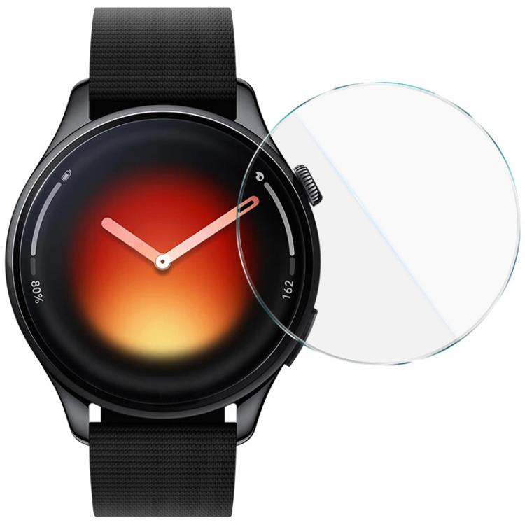 IMAK clear, round tempered glass screen protector beside a black watch