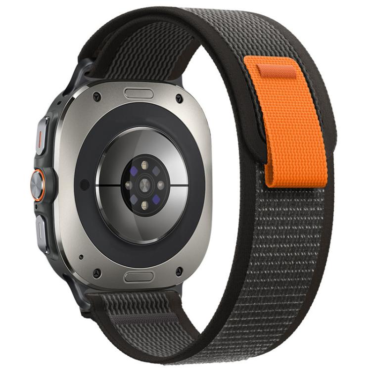 Black nylon hook-and-loop watch band with an orange closure tab