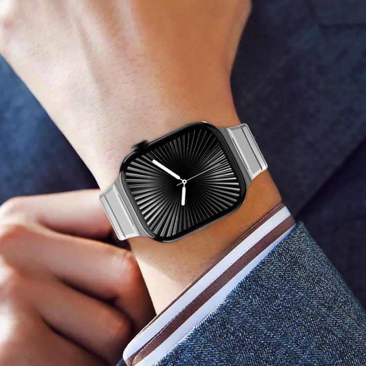 Silver metal watch band shown on a wrist with a black-faced watch.