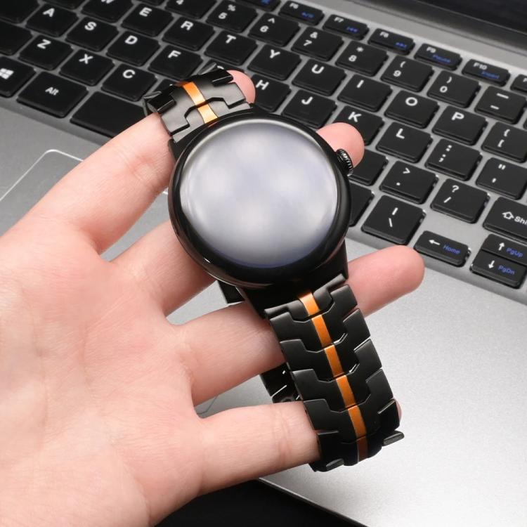Black and orange stainless steel watch band fitted to a round smartwatch