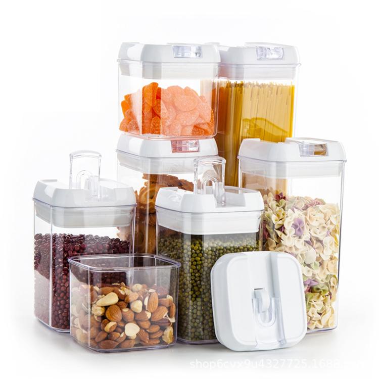 Food storage container set with multiple clear jars and white lids, filled with snacks and pasta