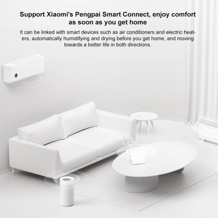 White no-mist humidifier standing on the floor near a white living room couch