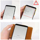 Hand inserting cards into a black leather RFID card holder with snap button