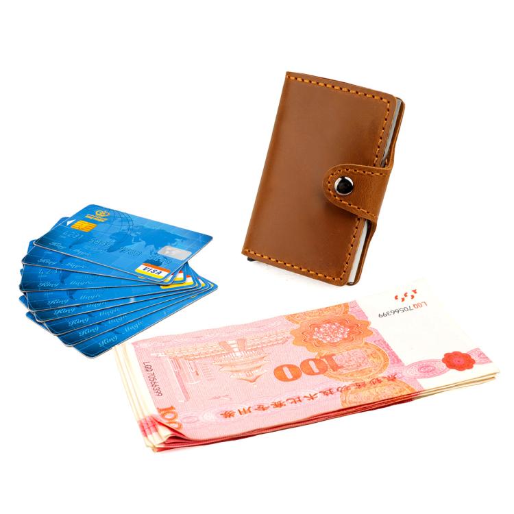 Brown leather card holder with snap strap, holding cards in an internal slot.