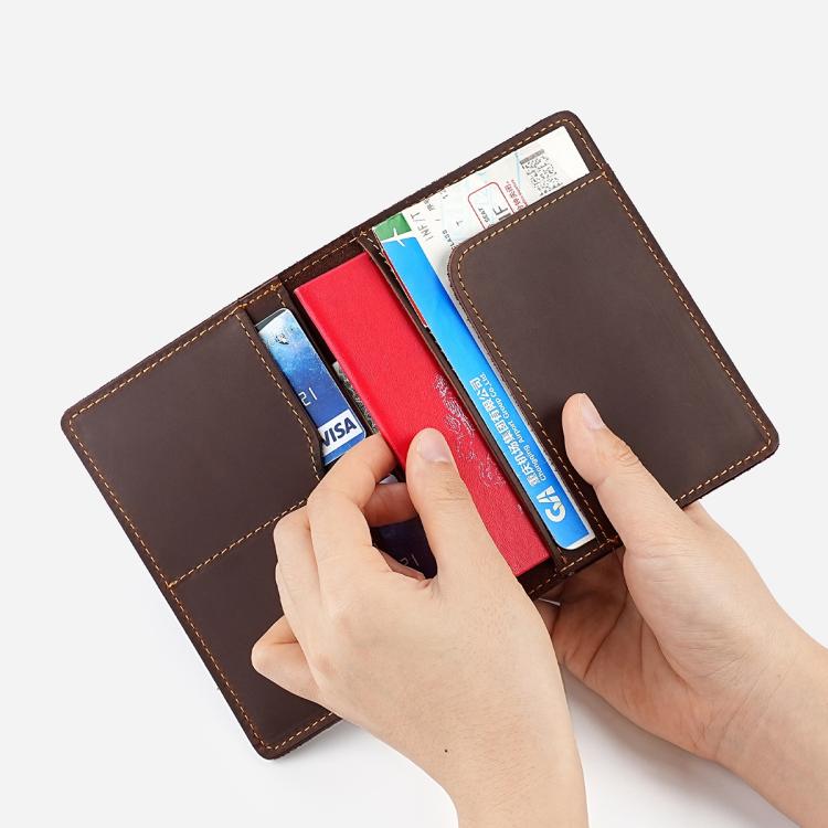 Genuine leather passport card holder wallet open with cards and a hand inserting items.