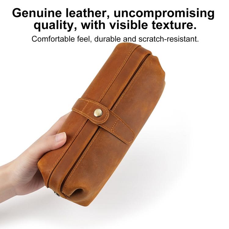 Genuine leather clutch bag in tan held in hand; top flap with snap closure.