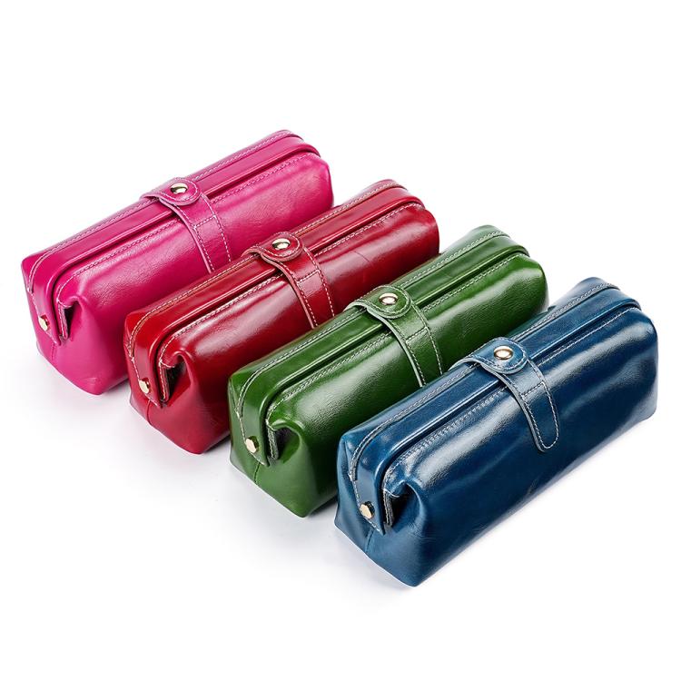 Set of three leather toiletry bags in pink, green, and blue with top zippers and loops