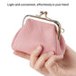 Pink pebble leather coin purse with kiss-lock frame, held in hand